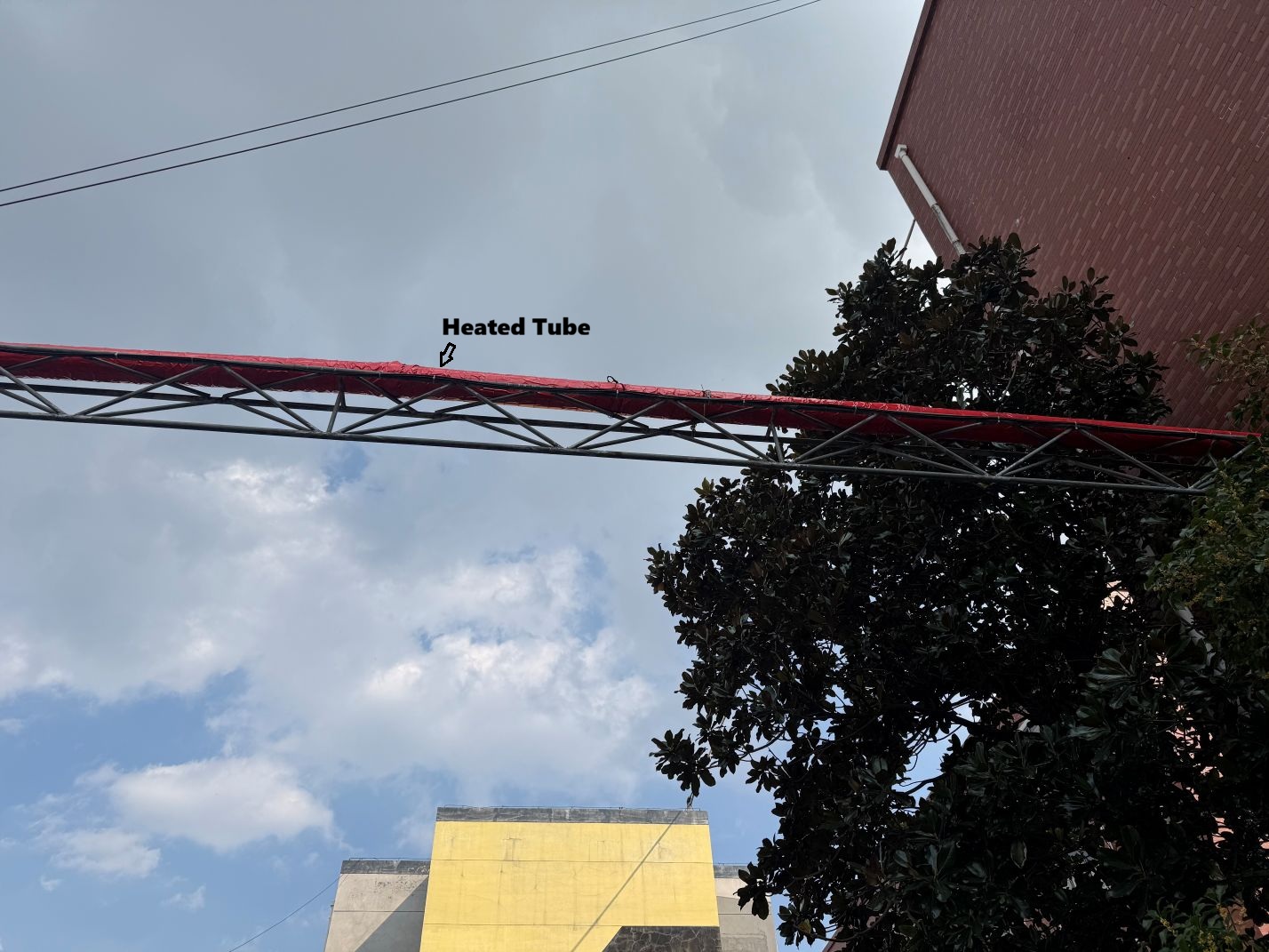 Overhead heated tube identified along the outdoor monitoring route